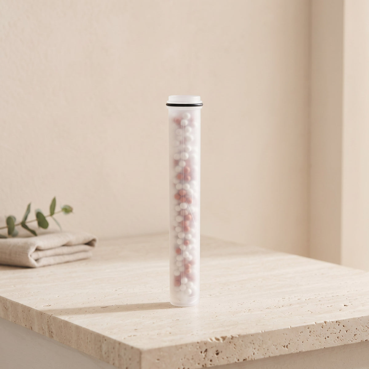 Illustration: one Driftrain refill cartridge standing on a travertine bathroom ledge (AI-made image)