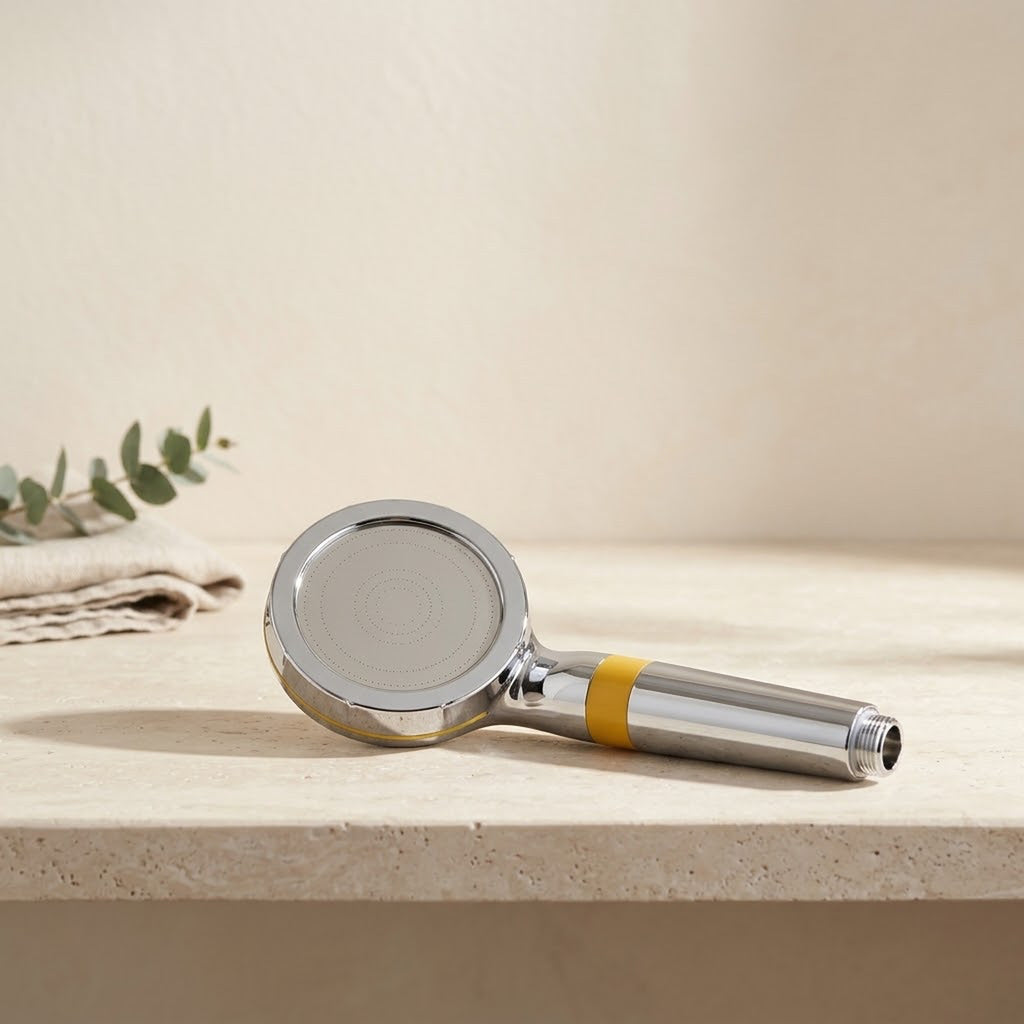 Illustration: the Driftrain chrome handheld with its yellow band lying on a travertine bathroom ledge (AI-made image)